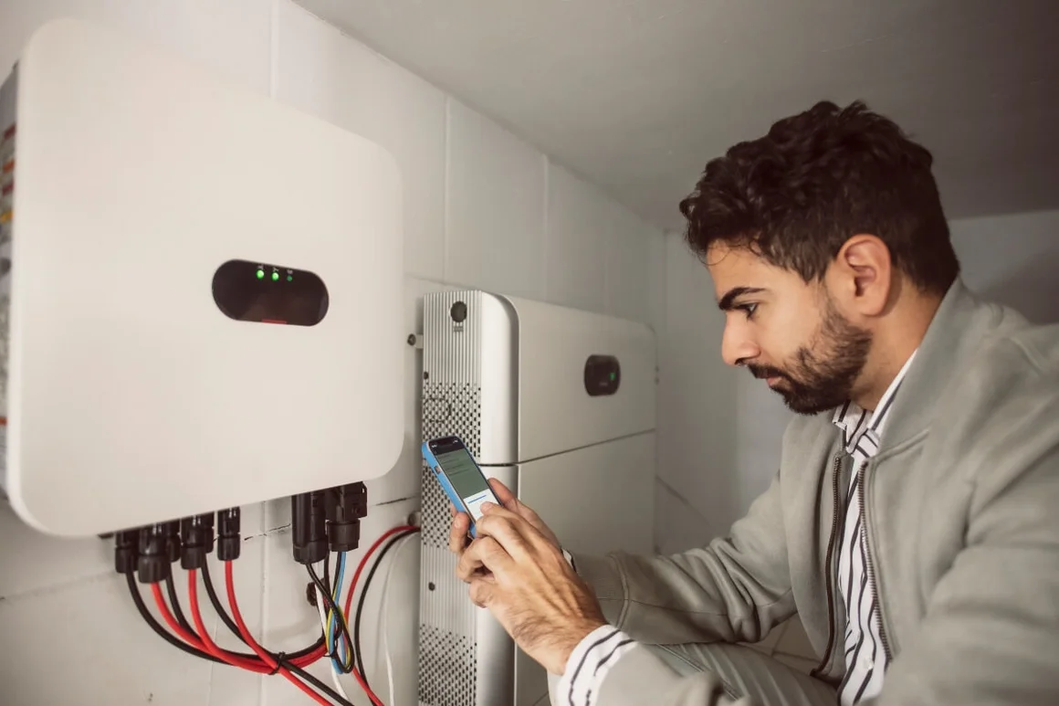 Person verwendet Smartphone an Elektrogerät
